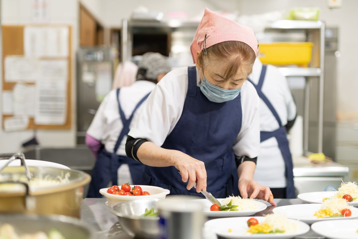 食堂スタッフが丁寧に料理を盛り付ける